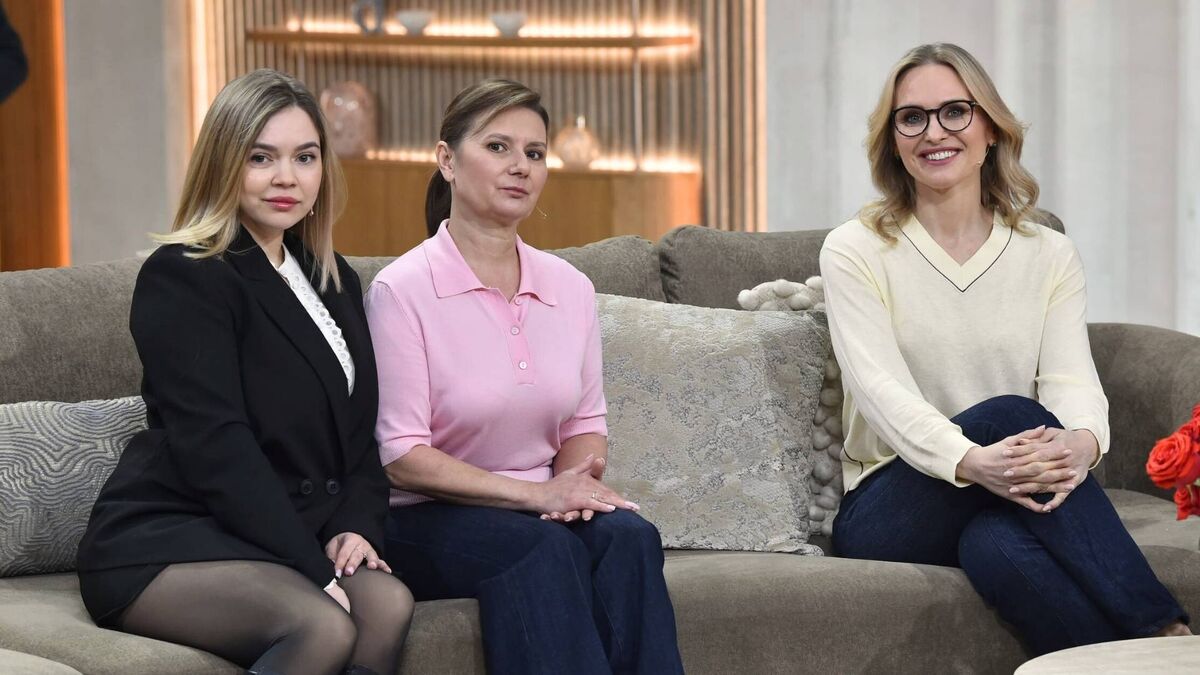 W studiu „Pytania na śniadanie” trzy kobiety pozują na kanapie w aranżacji przypominającej salon, gotowe do rozmowy w programie. Po lewej siedzi blondynka w czarnej stylizacji, w środku kobieta w różowej koszulce polo, a po prawej prowadząca w jasnym swetrze i okularach uśmiecha się do kamery. Ciepłe oświetlenie i neutralna scenografia w tle podkreślają spokojny, lifestyle’owy charakter ujęcia.